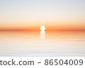 Sun on horizon of water with waves on blue sky 86504009