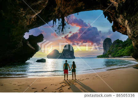 Young couple enjoying beautiful sunset at Railay beach, Krabi in Thailand. Young couple enjoying beautiful sunset at Railay beach, Krabi in Thailand. 86505336