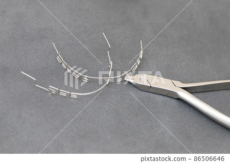 drawing up a multiloop ortho-arc on a gray background in a special tool. dentistry, beautiful smile 86506646