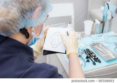 Isolation of the tooth for medical manipulations with a cofferdam. Preparing the rubber dam for use. 86506663