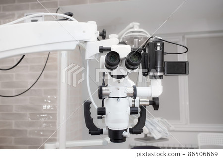 Dental microscope with video camera. against the background of modern dentistry. Medical equipment. operating microscope. with swivel double binoculars. dental microscope. an office in a white office 86506669