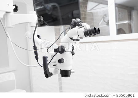 Dental microscope with video camera. against the background of modern dentistry. Medical equipment. operating microscope. with swivel double binoculars. dental microscope. an office in a white office 86506901
