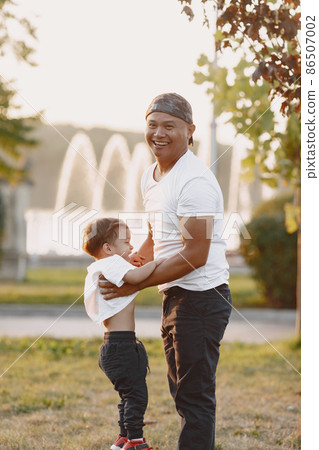 Father and son having fun in summer park Father and son having fun in summer park 86507002