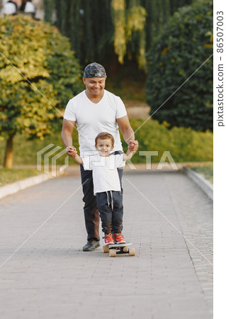 Father and son having fun in summer park Father and son having fun in summer park 86507003