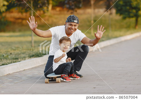 Father and son having fun in summer park Father and son having fun in summer park 86507004