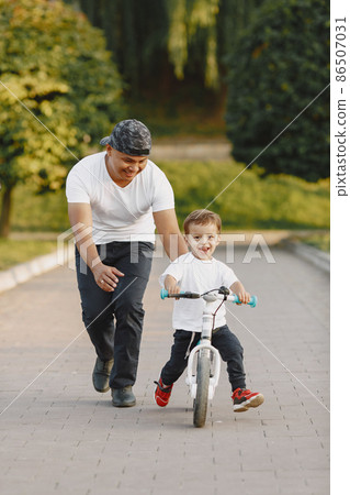 Father and son having fun in summer park Father and son having fun in summer park 86507031