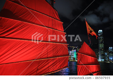 Chinese red junk with the victoria harbor night view background in hong kong Chinese red junk with the victoria harbor night view background in hong kong 86507935