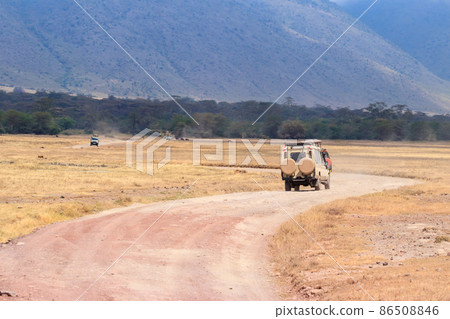 Off road cars driving in Ngorongoro crater. African safari in Ngorongoro Crater National park in Tanzania Off road cars driving in Ngorongoro crater. African safari in Ngorongoro Crater National park in Tanzania 86508846