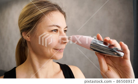Beautiful woman is using vacuum device for removing blackheads 86508917