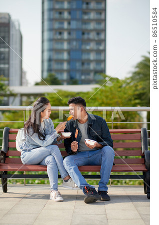 Woman Sharing Corn Dog with Boyfriend Woman Sharing Corn Dog with Boyfriend 86510584