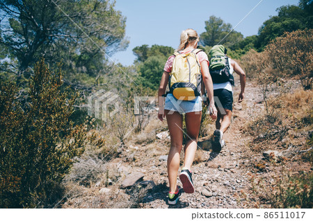 Couple of hikers walking up path together 86511017