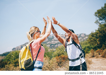 Cheerful backpackers meeting for hiking together in sunny day 86511045