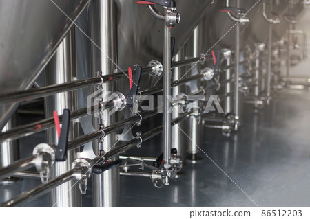 Modern Beer Factory. Steel tanks for beer fermentation and storage. Brewery. Modern beer plant with brewering kettles Modern Beer Factory. Steel tanks for beer fermentation and storage. Brewery. Modern beer plant with brewering kettles 86512203