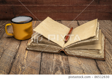 antique leather-bound journal on rustic wood 86512630