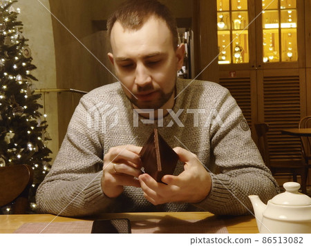 A sad, bearded man, in a sweater, with a ring, looks into an empty wallet after the New Year holidays, in a restaurant. The guy ran out of money, can't pay A sad, bearded man, in a sweater, with a ring, looks into an empty wallet after the New Year holidays, in a restaurant. The guy ran out of money, can't pay 86513082