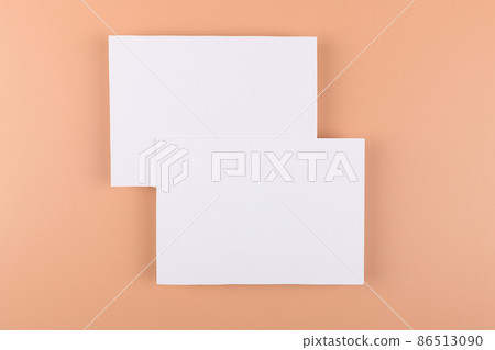 Card mockup of two empty white 5x7 card invitations on beige or terracotta nude background. 86513090