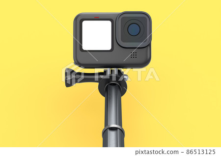Photo and video lightweight black action camera with selfie stick on yellow 86513125