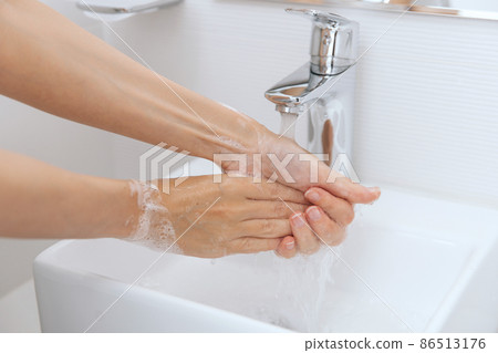 Washing hands under the flowing water tap. Hygiene concept hand detail. Washing hands rubbing with soap for corona virus prevention, hygiene to stop spreading corona virus in or public wash room. 86513176