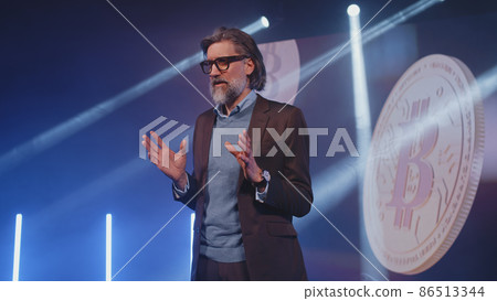 Male coach talking about bitcoin on a stage Male coach talking about bitcoin on a stage 86513344