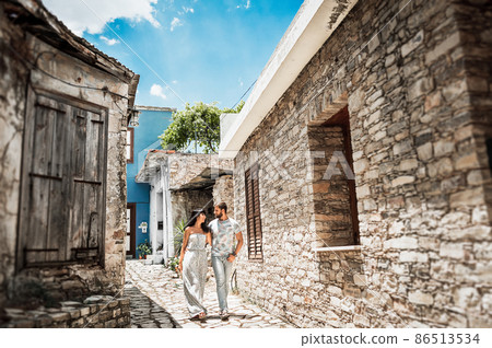 A couple in love walks the streets of the Old city. The couple travels to Cyprus. Guy and girl walking. Follow me. Man and woman traveling. Narrow street. Lover. Walking in the old town. Loving couple A couple in love walks the streets of the Old city. The couple travels to Cyprus. Guy and girl walking. Follow me. Man and woman traveling. Narrow street. Lover. Walking in the old town. Loving couple 86513534