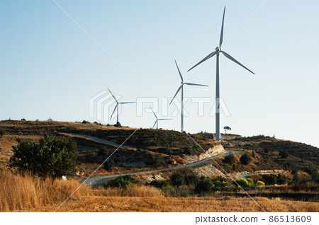 Wind turbine in field. Wind generator. Wind power plant. Electric energy. Road in field. The Nature Of Cyprus. Road through wind turbines. Electricity from wind 86513609