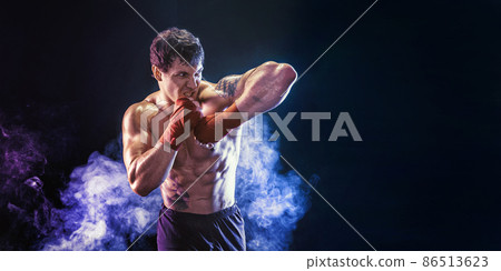 Kickboxer delivering an elbow hit isolated on smoke background. Sport concept, mixed martial arts 86513623