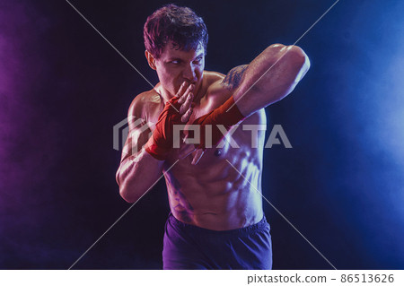 Muay thai fighter delivering elbow hit isolated on black background. Sport concept. mixed media  86513626