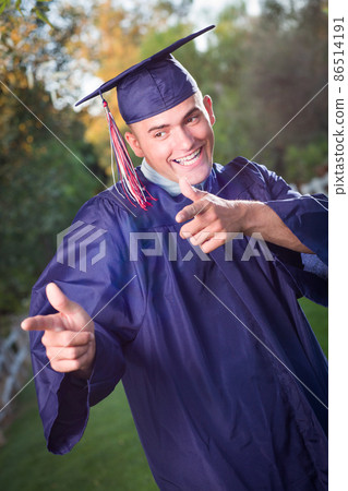 Happy Handsome Male Graduate in Cap and Gown Outside. 86514191