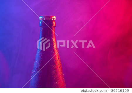 Glass bottle of beer in blue pink mist Glass bottle of beer in blue pink mist 86516109