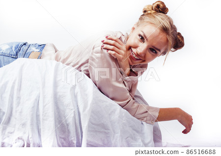 young pretty blond woman laying in bed isolated on white background, lifestyle people concept 86516688