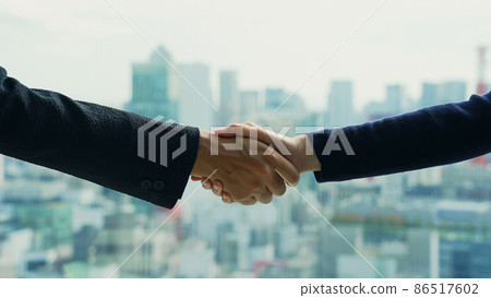 Business person shaking hands against the backdrop of the city Business person shaking hands against the backdrop of the city 86517602