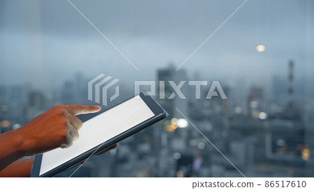 Men using tablets against the backdrop of the city Men using tablets against the backdrop of the city 86517610