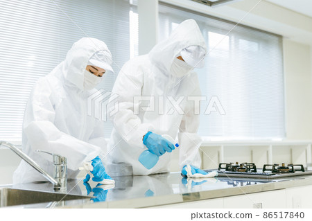 Male and female staff in dustproof clothing to disinfect and clean the kitchen Male and female staff in dustproof clothing to disinfect and clean the kitchen 86517840