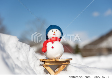 Blue sky and snowman on the deck 86518707