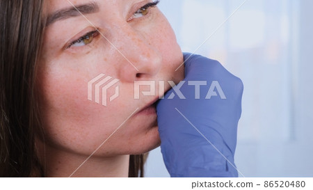 Intra oral neuromuscular massage. Female professional beautician makes facial massage to herself Intra oral neuromuscular massage. Female professional beautician makes facial massage to herself 86520480