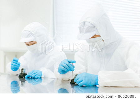 Men and women assembling precision equipment 86520893