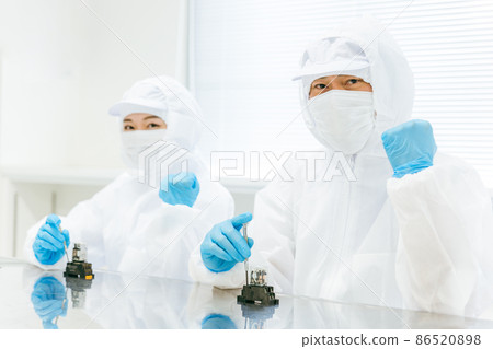 Men and women assembling precision equipment 86520898