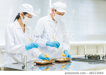 Men and women serving lunch boxes (food processing / gloves) 86521664