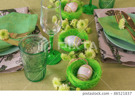 Set table with Easter decoration - eggs in nests and flowers. 86521837
