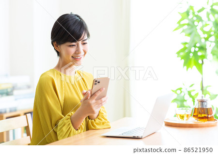 在客廳使用筆記本電腦和智能手機的女性生活方式 86521950