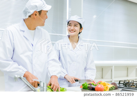 Male and female cooks working in food factories, school lunch centers, and supermarkets Male and female cooks working in food factories, school lunch centers, and supermarkets 86521959