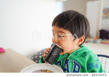 A 3-year-old boy eating seaweed rolls for lunch 86524453