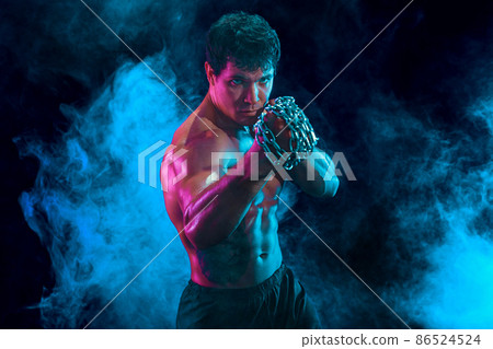Portraite of Muscular fighter who delivering hit with chain on smoke background. mixed media Portraite of Muscular fighter who delivering hit with chain on smoke background. mixed media 86524524