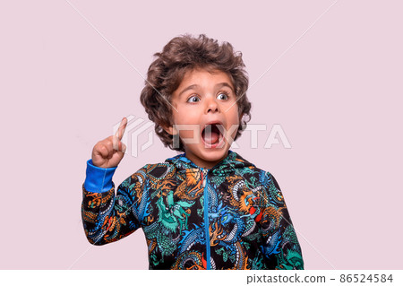 Portrait of smart hispanic kid with finger pointing up. Clever cheerful wavy haired boy creating new cool idea knowledge. Portrait of child fantasize. Amazed face with open mouth. Kindergarten, school 86524584