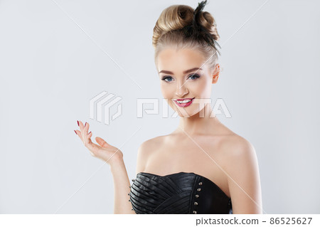 Fashion portrait of glamorous model woman holding empty open hand on white Fashion portrait of glamorous model woman holding empty open hand on white 86525627