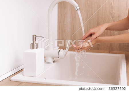 Washing hands under the flowing water tap. Washing hands rubbing with soap for corona virus prevention, hygiene to stop spreading corona virus in or public wash room. Hygiene concept hand detail. 86527592