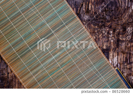 Green bamboo napkin on a dark wooden background. Green bamboo napkin on a dark wooden background. 86528660