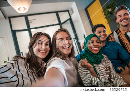 Group of business people during break from the work taking selfie picture while enjoying free time in relaxation area at modern open plan startup office. Selective focus  86529715