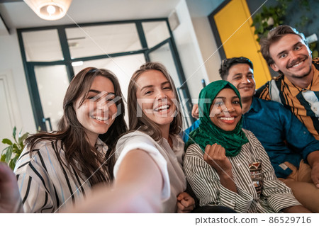 Group of business people during break from the work taking selfie picture while enjoying free time in relaxation area at modern open plan startup office. Selective focus  86529716