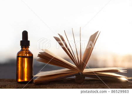 Alternative medicine - open old book and bottles. 86529983